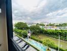 View from the balcony overlooking a parking lot, trees, canal, and city buildings