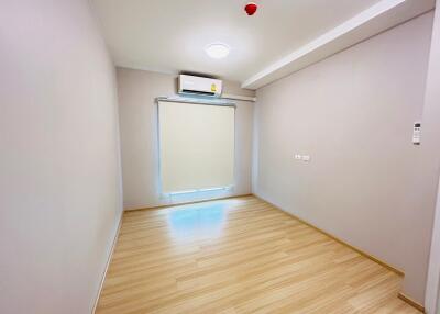 Empty bedroom with wooden flooring and an air conditioner