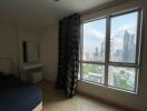 Modern bedroom with large window and city view