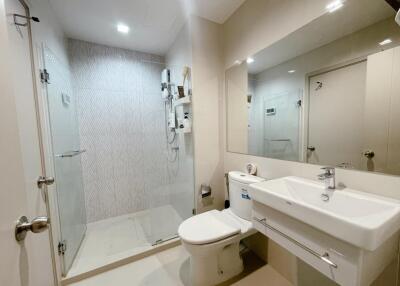 Modern bathroom with shower, toilet, and large mirror