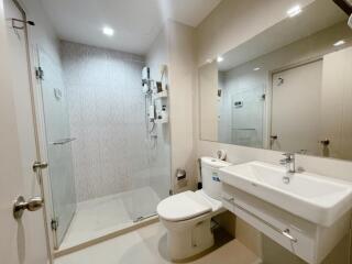 Modern bathroom with shower, toilet, and large mirror