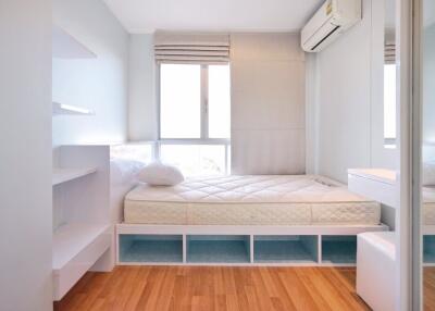 Well-lit bedroom with a bed, air conditioner, and storage space