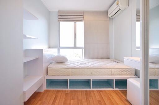 Well-lit bedroom with a bed, air conditioner, and storage space