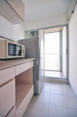 Modern kitchen with appliances and access to balcony