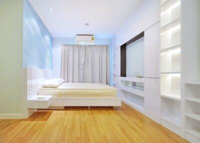 Modern bedroom with built-in storage and wooden flooring