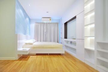 Modern bedroom with built-in storage and wooden flooring