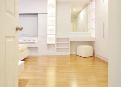 Spacious modern bedroom with wooden flooring and ample storage