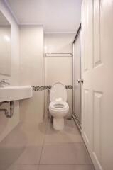 Compact modern bathroom with toilet, sink, and shower