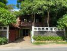 Front view of a residential house surrounded by trees