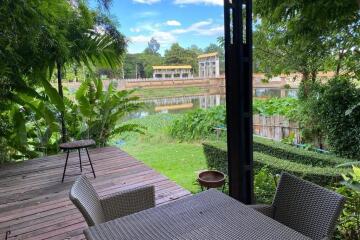 Outdoor patio with a view of a lake and greenery