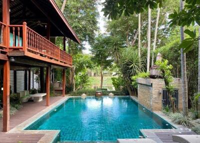 Beautiful outdoor pool area with lush greenery and seating