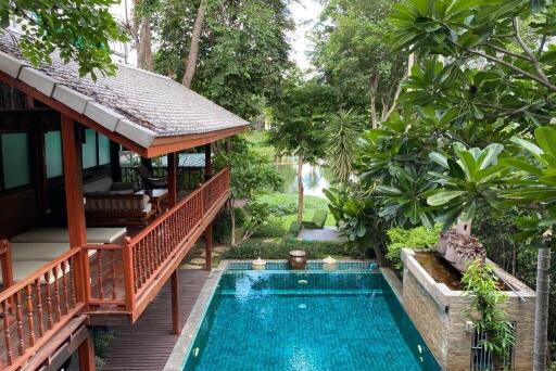 Outdoor area with a swimming pool and a covered wooden patio