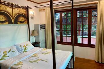 cozy bedroom with large windows and a four-poster bed