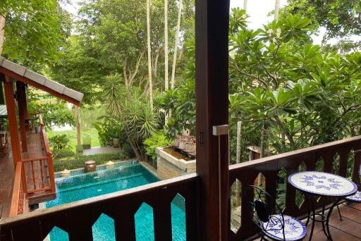 View of a backyard with pool and garden from a balcony