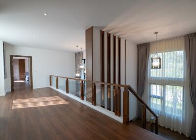 Spacious and well-lit stairway area with wooden flooring