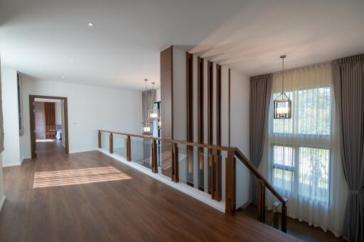 Spacious and well-lit stairway area with wooden flooring