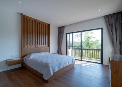 Spacious bedroom with large windows and a wooden accent wall