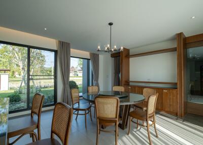 Spacious dining room with large windows and wooden chairs