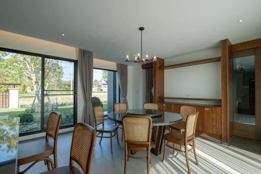 Spacious dining room with large windows and wooden chairs