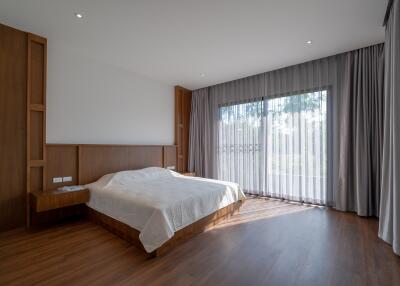 Spacious bedroom with large window and wooden flooring