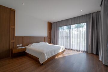 Spacious bedroom with large window and wooden flooring