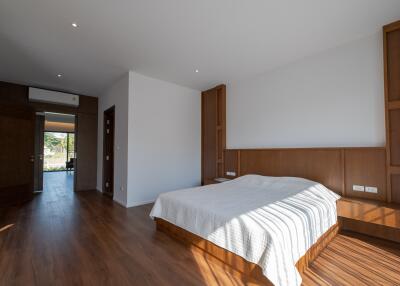 Spacious bedroom with wooden flooring and large bed