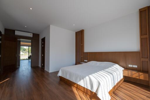 Spacious bedroom with wooden flooring and large bed