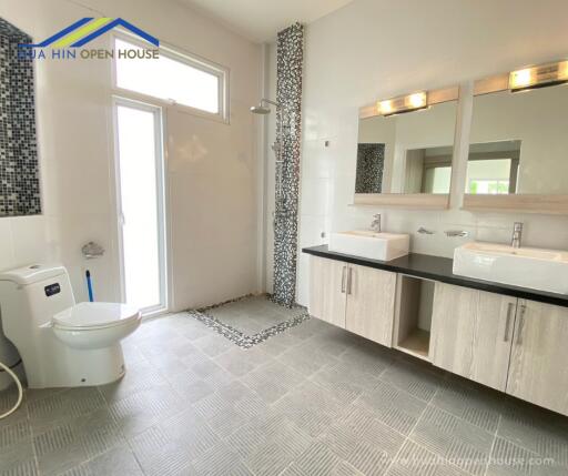 Spacious modern bathroom with dual sinks and walk-in shower