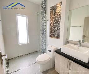 Modern bathroom with glass shower and tiled walls