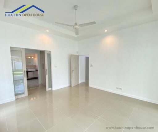 Living room with ceiling fan, tiled floor, and view of kitchen