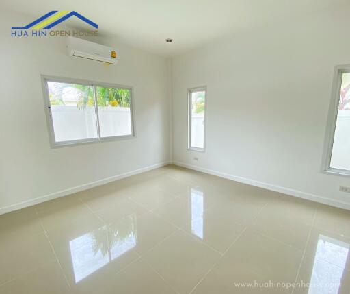 Bright and empty bedroom with large windows and white walls