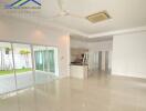 Spacious modern living area with sliding doors to the outside, featuring tiled floors, ceiling fan, and adjacent kitchen.