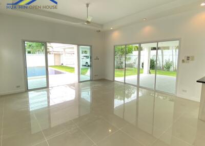 Spacious living room with large windows and tile flooring