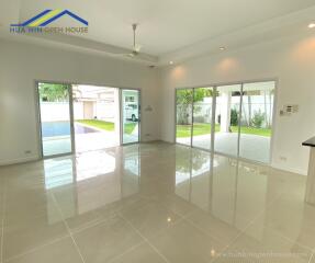 Spacious living room with large windows and tile flooring