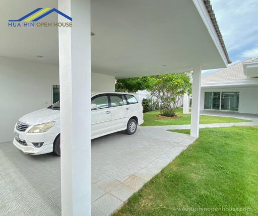 Covered carport with a white car parked next to a modern house