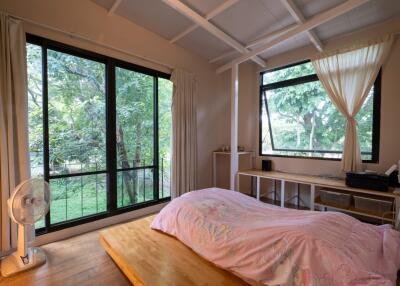 Cozy bedroom with large windows and nature view