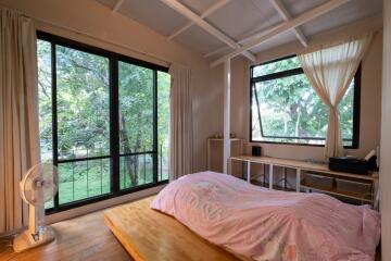 Cozy bedroom with large windows and nature view