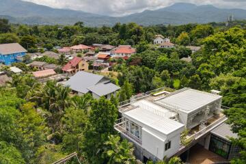 Aerial view of residential neighborhood with surrounding greenery and mountains