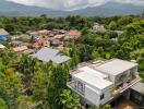 Aerial view of residential neighborhood with surrounding greenery and mountains