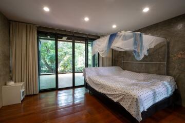 Bedroom with large windows and a canopy bed