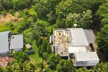 Aerial view of a house surrounded by greenery