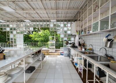 Outdoor kitchen with white tiled counters and open shelving