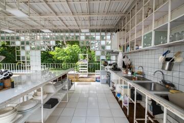 Outdoor kitchen with white tiled counters and open shelving