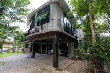 Exterior view of a modern two-story house with large windows and a balcony