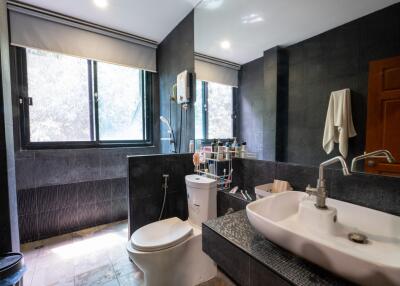 Modern bathroom with large windows, sink, and toilet