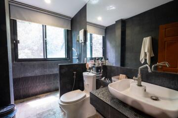 Modern bathroom with large windows, sink, and toilet