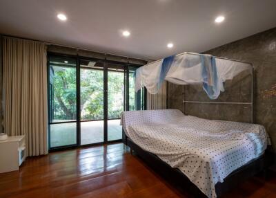 Spacious bedroom with large windows and a canopy bed