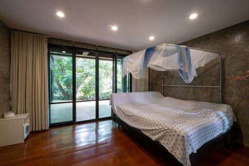 Spacious bedroom with large windows and a canopy bed