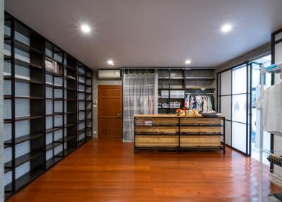 Spacious walk-in closet with wooden floors and built-in shelves