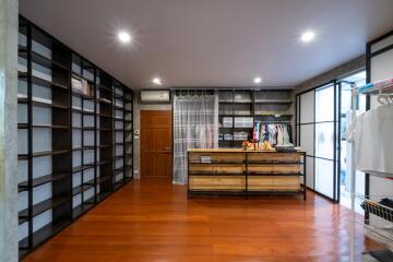 Spacious walk-in closet with wooden floors and built-in shelves